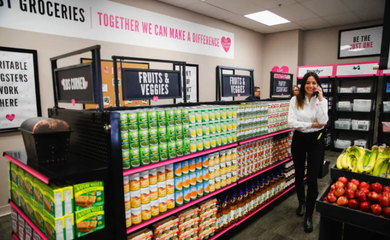 A woman standing in front of an aisle of food.